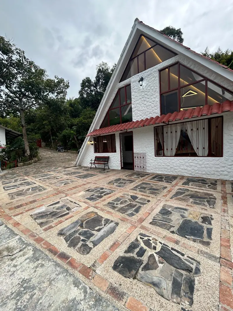 Fachada del chalet con grandes ventanales y techo de teja