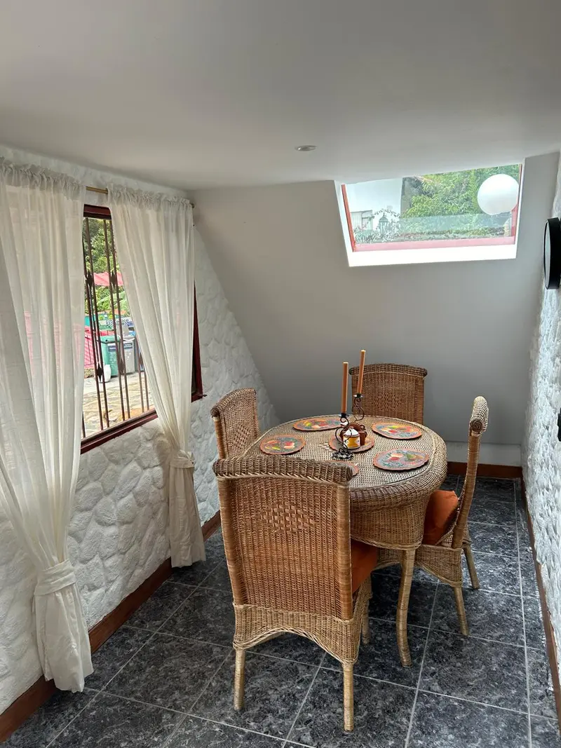 Comedor con mesa de mimbre y ventana a la naturaleza