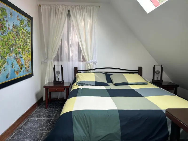 Habitación con cama doble y mapa en la pared