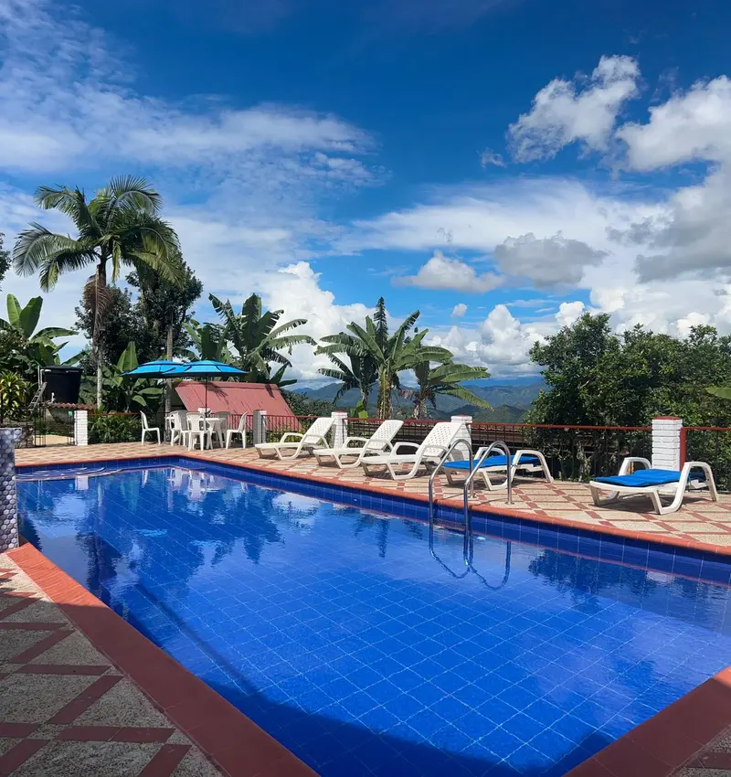 Piscina con zona de mesas y sombrillas